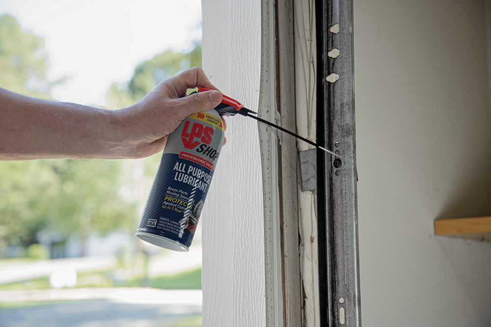 LPS Shop All Purpose Lubricant spraying garage door rollers.